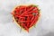 Hot chili peppers in a heart-shaped straw basket. Spicy food love concept