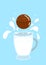 hot chocolate bomb with milk splash on a blue background and with a mug of milk