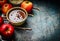 Hot chocolate in bowl and red apples with twigs , ingredients for sweet apples making, preparation on rustic background