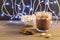 Hot chocolate, cinnamon sticks and marshmallow on the background of burning garlands, Christmas decorations