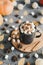 Hot chocolate with marshmallow, cocoa powder, star anise and cinnamon served in a black mug, pumpkins and dried yellow leaves as a