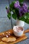 Hot chocolate with marshmallows and homemade stamped butter cookies next to the lilac