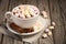 Hot chocolate with marshmallows and spices on the rustic wooden table