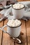 Hot chocolate with marshmallows in two enamel mugs