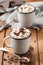 Hot chocolate with marshmallows in two enamel tin mugs