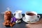 Hot chocolate and milk, cup of cocoa, chocolate cookies, almonds, flowers on a shale board on bright blue background, place to cop