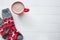 Hot chocolate in red cup and red socks with christmas traditional background on white wooden table background, copy space. Top vi