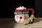 Hot chocolate Santa Clause cute mug with marshmallows, and gingerbread on wooden table with copy space