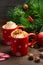 Hot chocolate with whipped cream in red cups. Christmas composition.