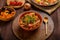 hot cholent sprinkled with green onions on a laid Shabbat table.