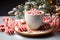 Hot Christmas cocoa drink with cream and lollipops on the background of lights and a fir branch on the table