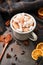 Hot cocoa drink with marshmallows in retro mug surrounded by ingredients