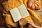 Hot cocoa, ripe pumpkin, warm sweater and open book on wooden background.