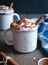 Hot cocoa with whipped cream and cinnamon stick on dark background