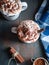 Hot cocoa with whipped cream and cinnamon stick on dark background, top view