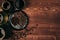 Hot coffee in black cup and turkish pots cezve with beans, saucer with copy space on brown old wooden board background, top view.