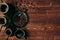 Hot coffee in black cup and turkish pots cezve with beans, saucer with copy space on brown old wooden board background, top view.