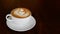 Hot coffee cappuccino latte art tulip foam in ceramic cup on dark wood table background