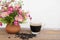 Hot coffee and coffee beans with flower clay pot.
