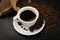 Hot coffee cup and coffee beans on black background top view