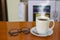 Hot Coffee cup and glasses on the wooden table and the office bl