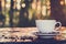 Hot coffee in the cup on old wood table with blur dark green nature background