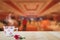 Hot coffee cup and red flower on wooden table top on blurred hotel lobby background
