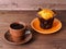 hot coffee in a Cup on a saucer, sweet tasty muffin, on brown wooden background, side view