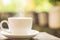 Hot coffee cup on wooden table over nature green morning background