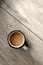 Hot coffee drink cup on neutral beige wooden table with sunlight shadows, minimalist aesthetic morning breakfast or coffee break