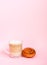 Hot coffee latte transparent glass cup on and sweet cinnamon roll on pink background