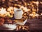 Hot coffee and red book with autumn leaves on wood background - seasonal relax concept