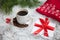 hot coffee, red warm pullover and gift with a red bow on a snowy background