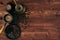 Hot coffee in shabby turkish pots cezve with beans, saucer with copy space on brown old wooden board background, top view.