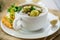 Hot cooked soup with Brussels sprouts, vegetables and croutons, in a plate.