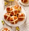 Hot cross buns, freshly baked hot cross buns on a white plate, top view.