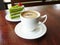 Hot cup of coffee cappuccino and layer green tea cake