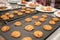 Hot delicious oatmeal cookies on baking tray from oven