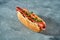 Hot dog with sausage, mozzarella, tomatoes and pesto in a white bun on a gray background. Selective focus. American fast food