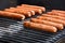 Hot dogs grilling on barbecue grill
