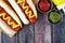 Hot dogs with mustard and ketchup, overhead scene on rustic wood