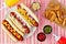 Hot dogs with potato wedges, above scene on checked cloth