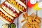 Hot dogs with potato wedges, above scene on rustic white wood
