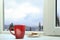 Hot drink and cookies near window with view of mountain landscape