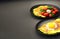 Hot eggs and omelets with cherry tomato, coriander and half boiled eggs on a black plate 3D illustration