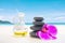 Hot fragrance oil aroma therapy massage with stone over blurred tropical summer beach background for relaxing image concept.