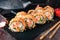 Hot fried Sushi Roll with salmon, shrimp, onion, avocado and cheese. Sushi menu.