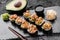 Hot fried Sushi rolls and maki set with smoked eel, cream cheese, avocado, caviar and wasabi on black slate background.