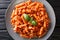 Hot hearty Tortiglioni pasta with bolognese sauce close-up in a plate. Horizontal top view