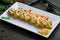 Hot kaisen roll with crab and spicy sause. chinese cuisine on dark stone table